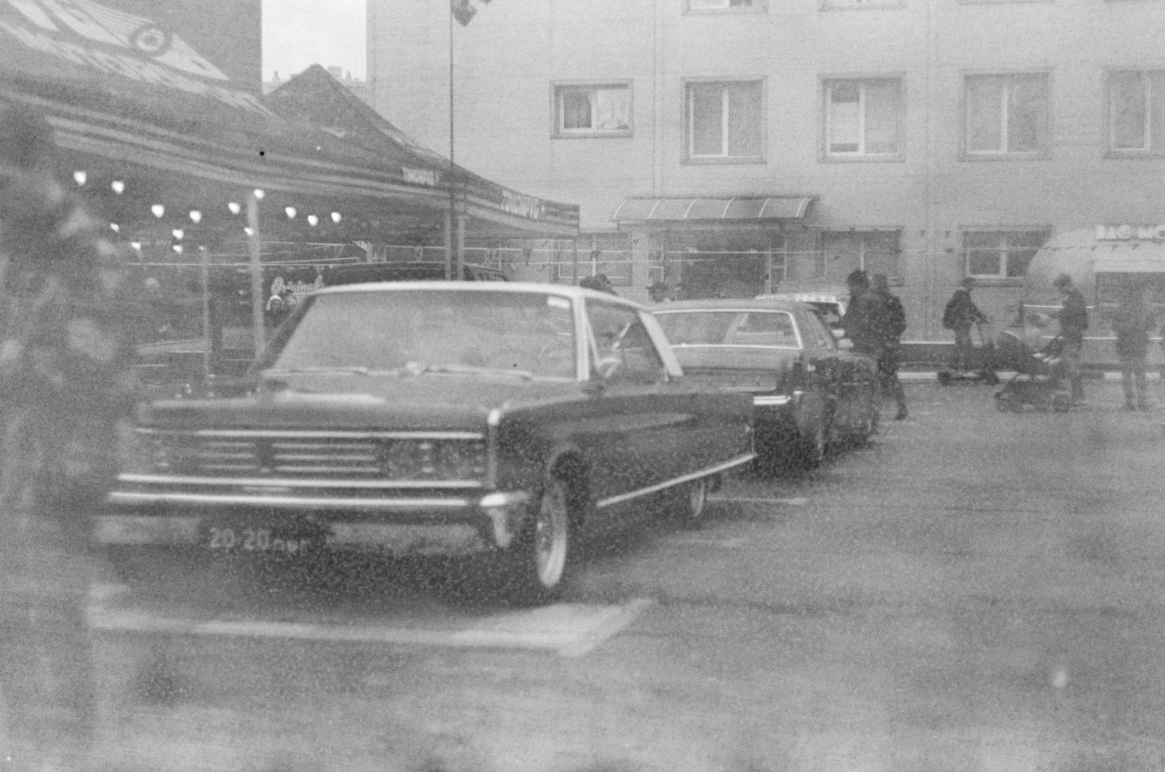 a black and white photo of cars parked in a parking lot, an album cover, by Petr Brandl, lowriders, photo taken with provia 1967, silent hill streets, tarmo juhola