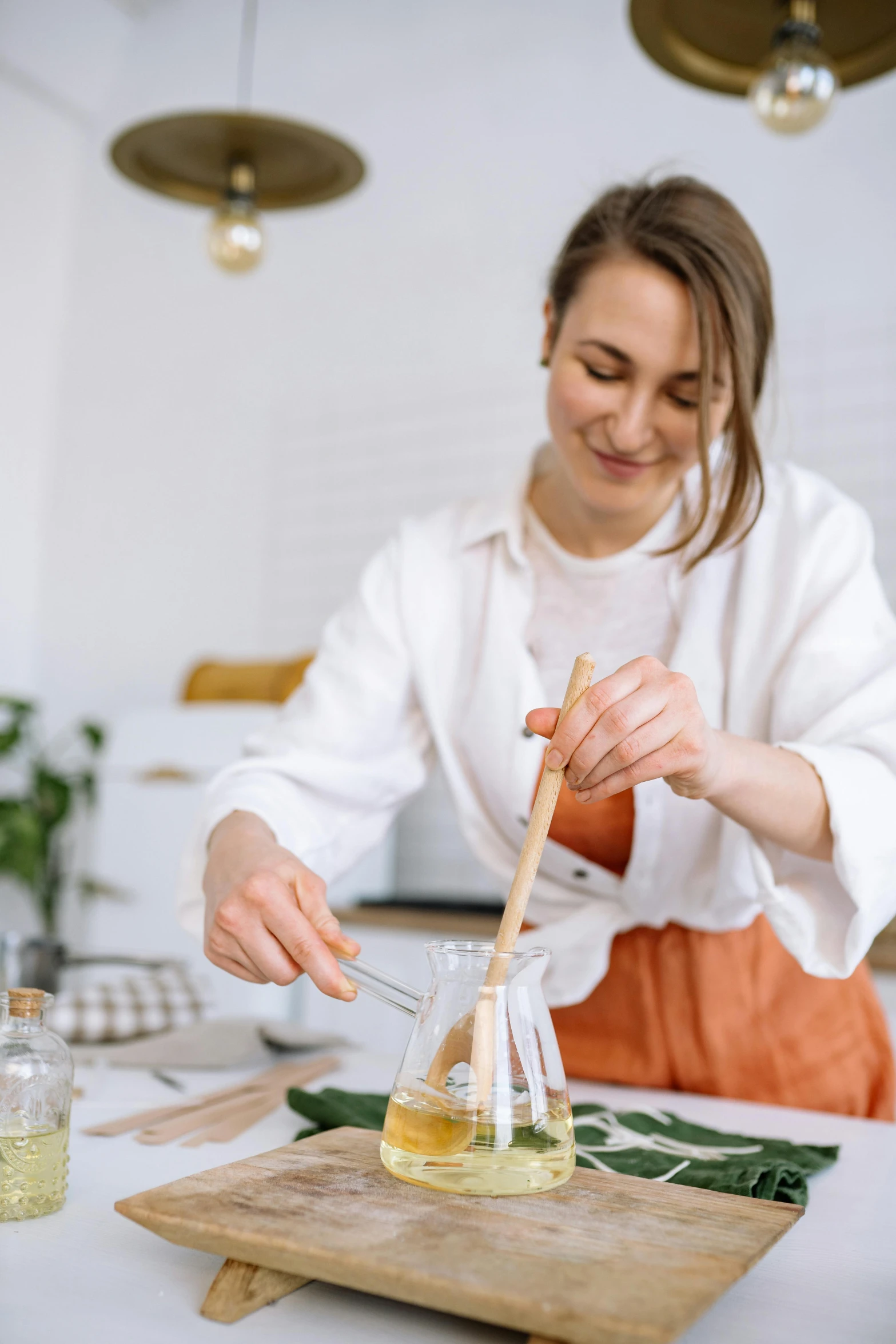 a woman preparing food in a kitchen on a cutting board, pexels contest winner, renaissance, inside a glass jar, on a white table, chopsticks, wearing lab coat and a blouse