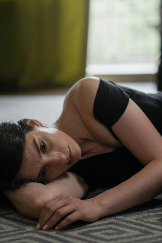 a woman laying on the floor next to a cat, inspired by Nan Goldin, unsplash, adam driver, rachel weisz, depressed dramatic bicep pose, androgyny