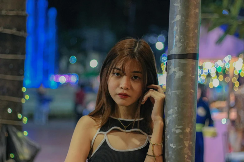 a woman leaning against a pole talking on a cell phone, pexels contest winner, realism, anime thai girl, night clubs and neons, she is wearing a black tank top, 🤤 girl portrait