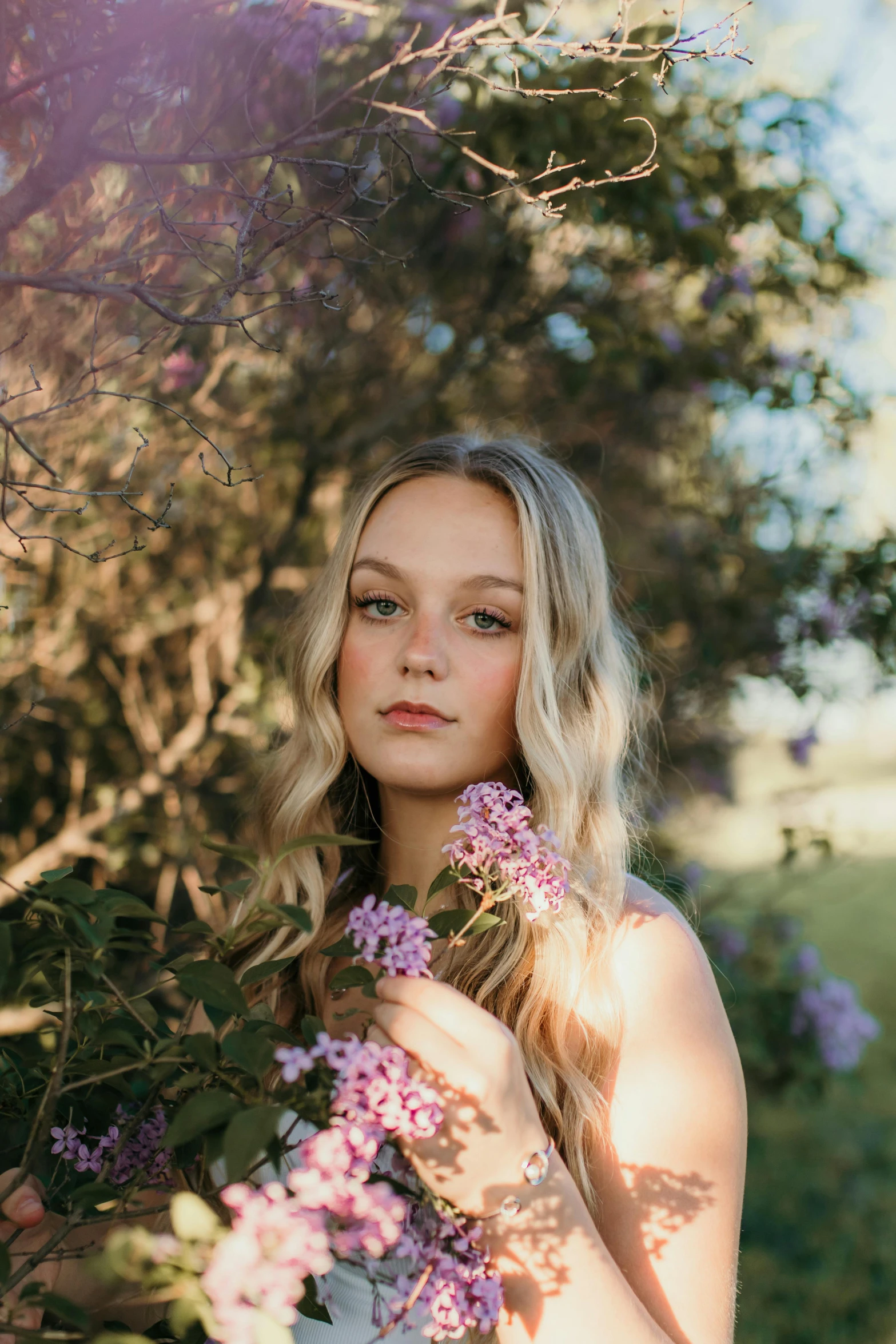 a woman holding a bunch of purple flowers, unsplash, portrait of annasophia robb, sydney hanson, profile image, 1 6 years old