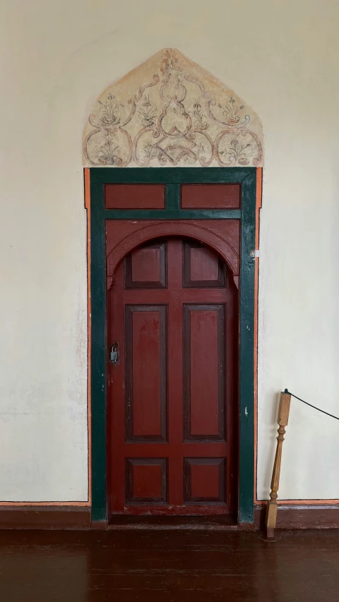 a wooden door sitting in the middle of a room, inspired by Balázs Diószegi, arts and crafts movement, red fluid on walls of the church, 1 8 th century style, photograph taken in 2 0 2 0, dug stanat