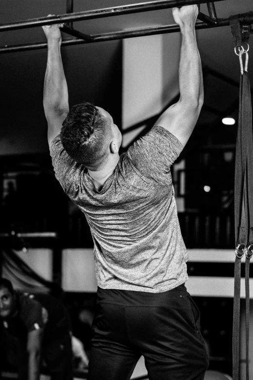 a man doing pull ups in a gym, a black and white photo, by Giorgio Cavallon, happening, live performance, suspenders, profile image, uploaded