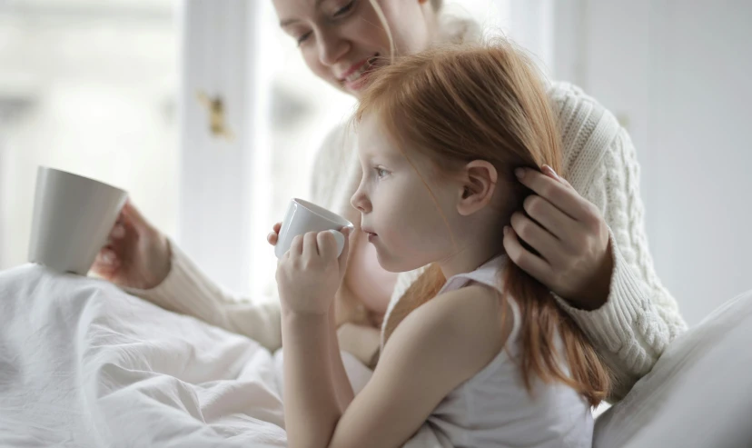 a woman combing a little girl's hair, pexels, visual art, with a cup of hot chocolate, ( redhead, someone in home sits in bed, manuka