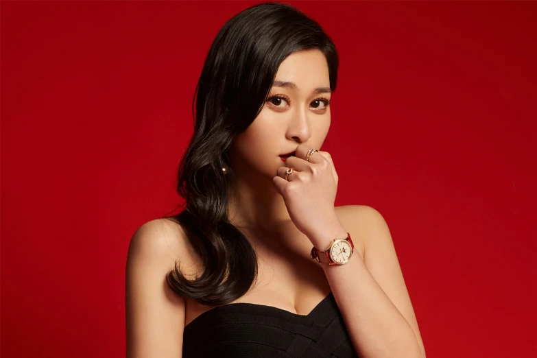 a woman in a black dress posing for a picture, an album cover, inspired by Zhang Shuqi, trending on pexels, gold watch, fine details. red, lovingly looking at camera, official store photo
