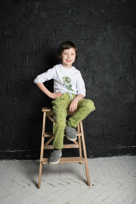 a young boy sitting on top of a wooden chair, inspired by Raphael, happening, fish net leggings, romanesco broccoli, official product photo, pants