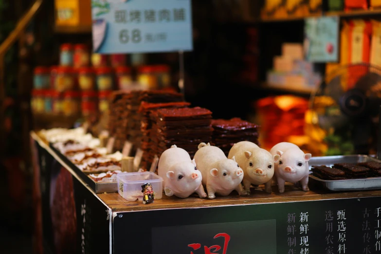 a bunch of pig figurines sitting on top of a table, a tilt shift photo, by Fei Danxu, with street food stalls, square, image