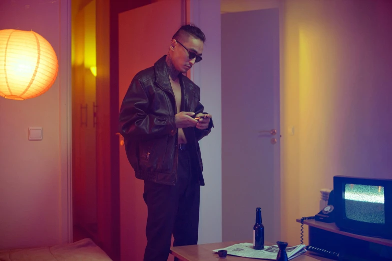 a man standing in a room looking at his cell phone, inspired by Nan Goldin, trending on pexels, bauhaus, singer maluma, cai xukun, movie still 8 k, cl