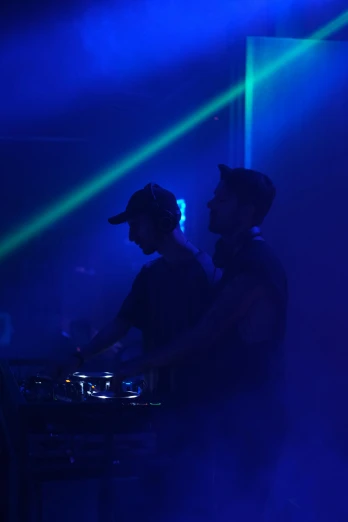 a couple of people that are standing in front of some lights, by Robbie Trevino, holography, playing techno house music, silhouetted, nick silva and ilya kuvshinov, college party
