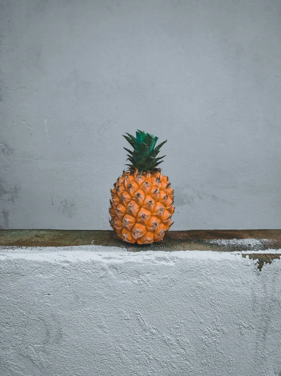 a small pineapple sitting on a ledge, inspired by Elsa Bleda, unsplash contest winner, hyperrealism, grey orange, low quality photo, made of glazed, high resolution product photo