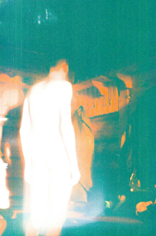 a group of people walking down a street at night, an album cover, ectoplasm, overexposed sunlight, translucent body, webcam screenshot