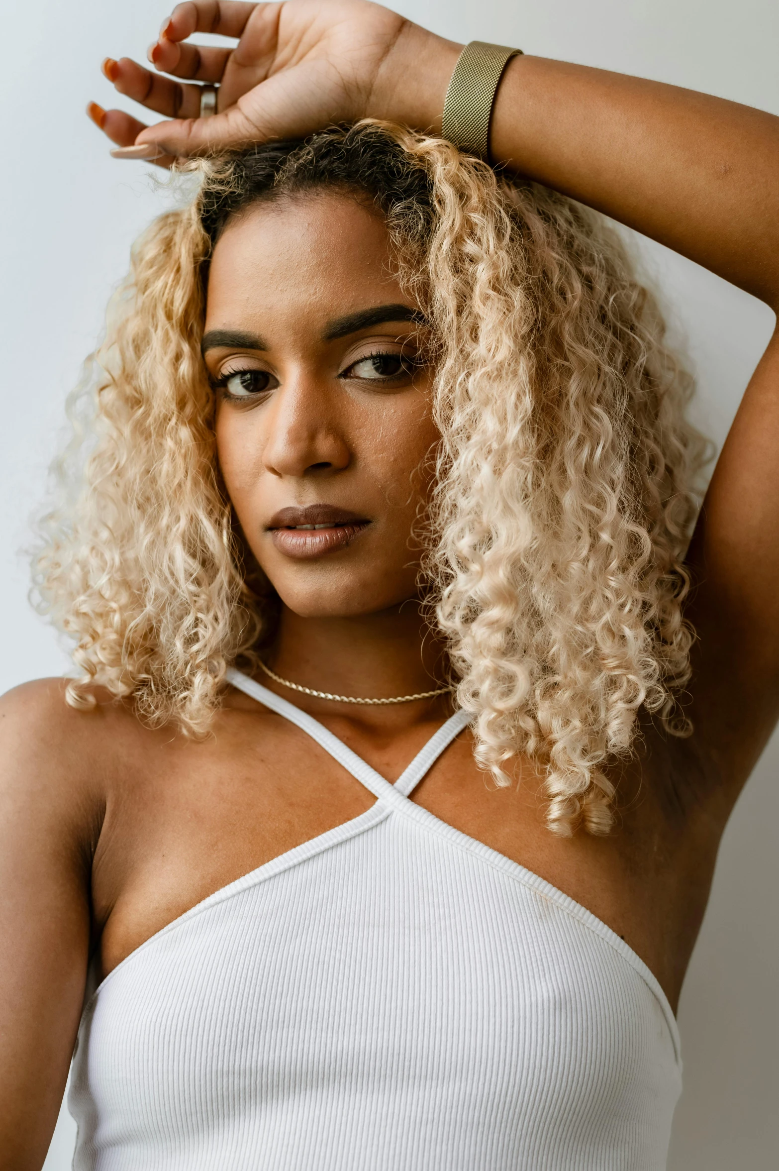 a woman with blonde hair wearing a white top, inspired by Esaias Boursse, trending on unsplash, she has olive brown skin, doja cat, white curly hair, pr shoot