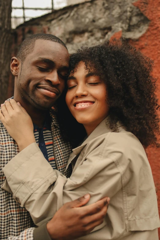 a man and a woman standing next to each other, trending on pexels, east african man with curly hair, two men hugging, brown, handsome girl