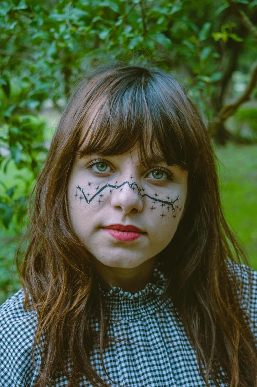 a girl with a cat face painted on her face, an album cover, inspired by Hannah Frank, messy bangs, facial tribal markings, parks, just