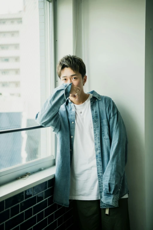 a man standing in front of a window talking on a cell phone, a picture, by Eizan Kikukawa, unsplash, shin hanga, portrait of kpop idol, wearing denim, 15081959 21121991 01012000 4k, smirking