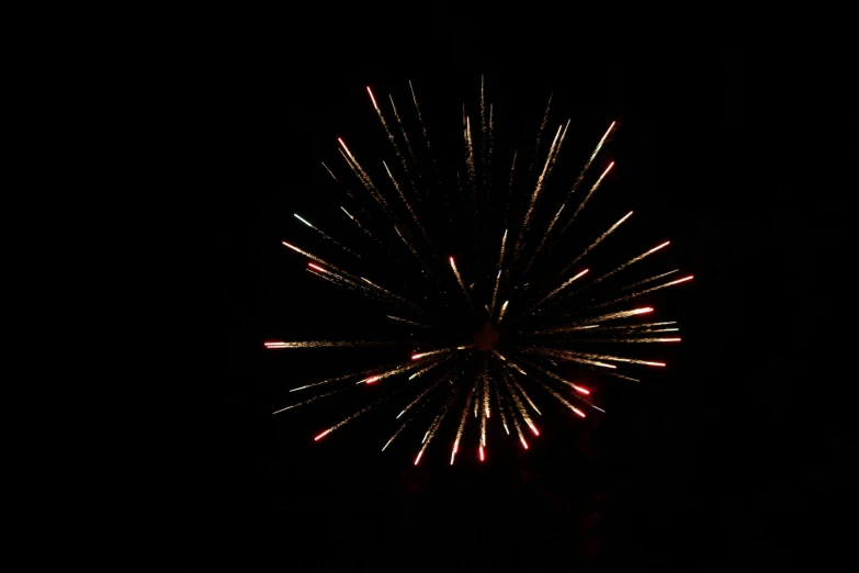 a firework is lit up in the dark, photo taken with provia, 3/4 view from below, red and white lighting, round-cropped