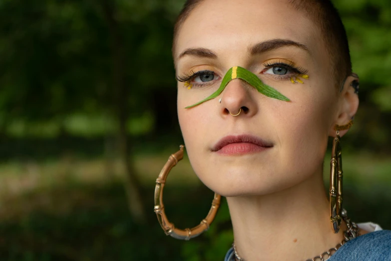 a woman with a green leaf on her nose, an album cover, trending on pexels, bamboo, body modification, aloy, hoop earrings