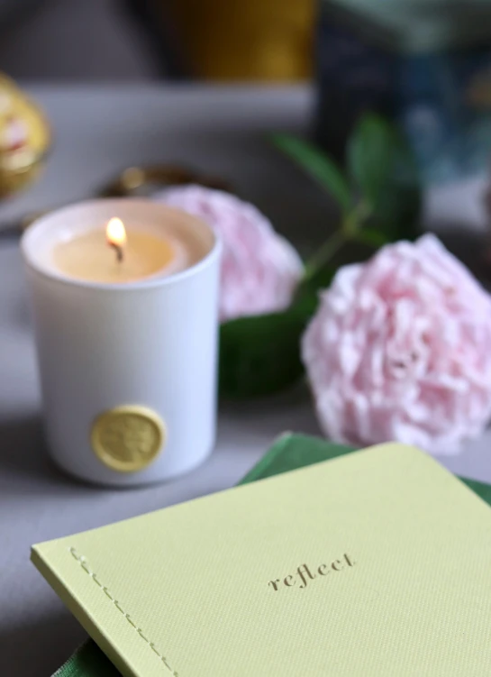 a book sitting on top of a table next to a candle, arabesque, yellow aureole, collection product, full perfect, hopeful and bright