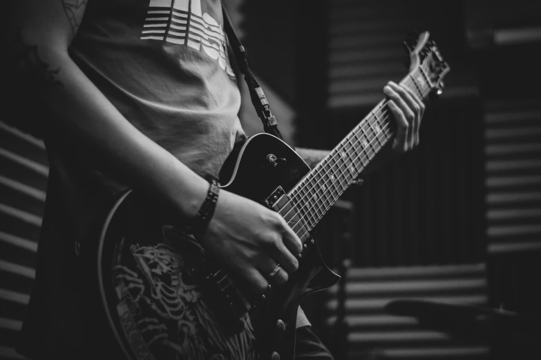 a black and white photo of a person playing a guitar, by Kristian Zahrtmann, pexels contest winner, holding a silver electric guitar, high quality upload, avatar image, band