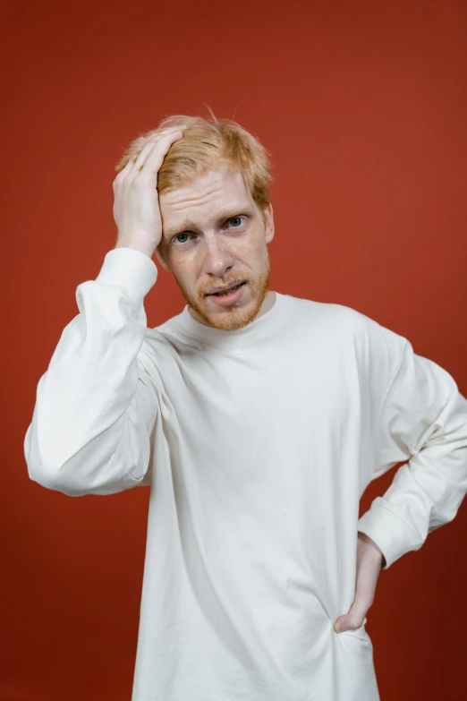 a man in a white shirt is holding his head, an album cover, by Lasar Segall, orange hair, looking confused, portrait photo of a backdrop, h3h3