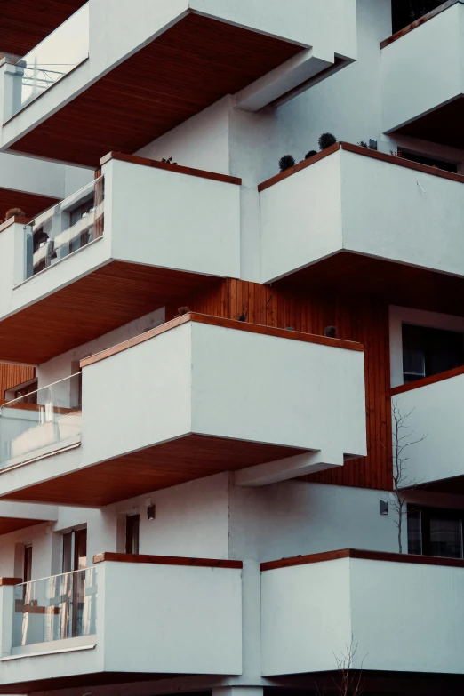 an apartment building with balconies and balconies on the balconies, an album cover, unsplash, giorgetto giugiaro, 1980s photograph, exterior photo, brown and white color scheme