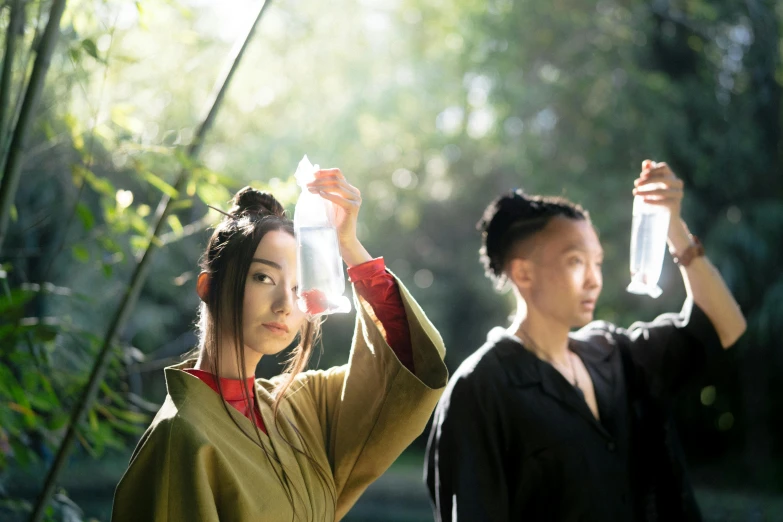 a couple of people standing next to each other, a portrait, inspired by Fu Baoshi, unsplash, holding a bottle, cosplay photo, al fresco, ( ( theatrical ) )