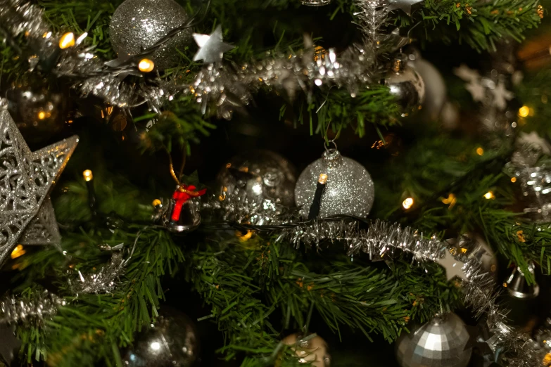 a close up of a christmas tree with ornaments, pexels, baroque, grey and silver, thumbnail, shot on sony a 7, detailed high resolution