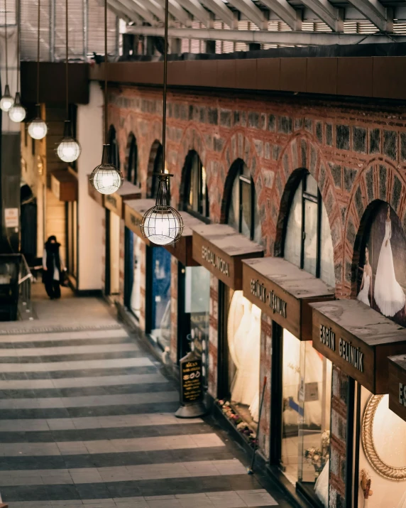 a couple of people that are standing in a building, warm street lights store front, dry archways, trending, in a row