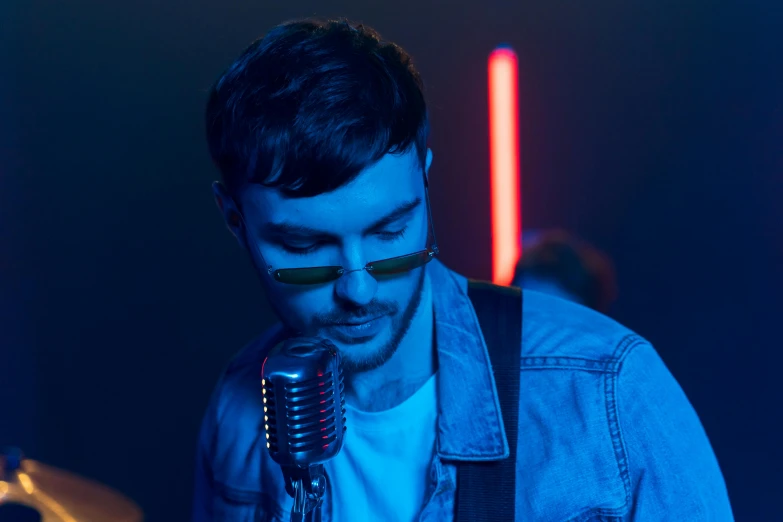 a man that is standing in front of a microphone, an album cover, inspired by James Morrison, pexels contest winner, photorealism, charli bowater, high blue lights, performing a music video, attractive man