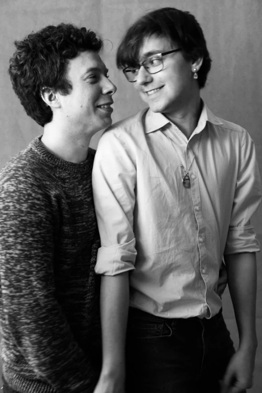 a couple of men standing next to each other, a black and white photo, by Felix-Kelly, rebecca sugar, in a photo studio, cute slightly nerdy smile, ( ( photograph ) )