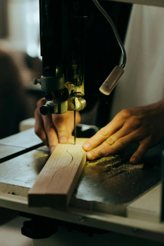 a person working on a piece of wood with a machine, by Jessie Algie, pexels contest winner, arts and crafts movement, low light, manly design, chopping hands, restomod