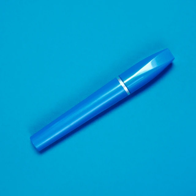 a blue pen sitting on top of a blue surface, mascara, product design shot, bright colour, 4 0 9 6