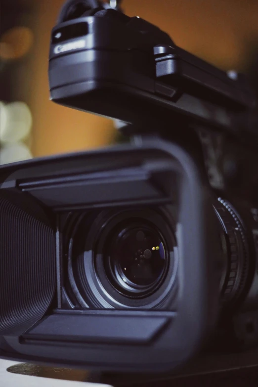 a video camera sitting on top of a table, close up to the screen, looking up at the camera, looking towards camera, film lighting