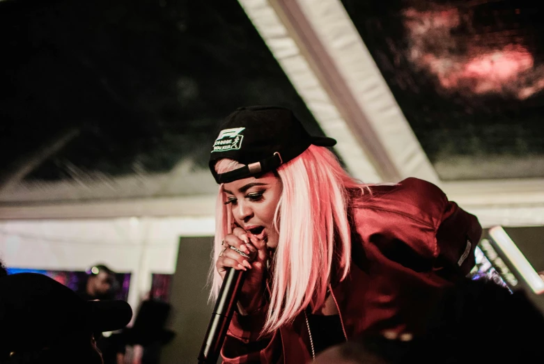 a woman with pink hair singing into a microphone, unsplash, bladee from drain gang, low fi, head down, rapper