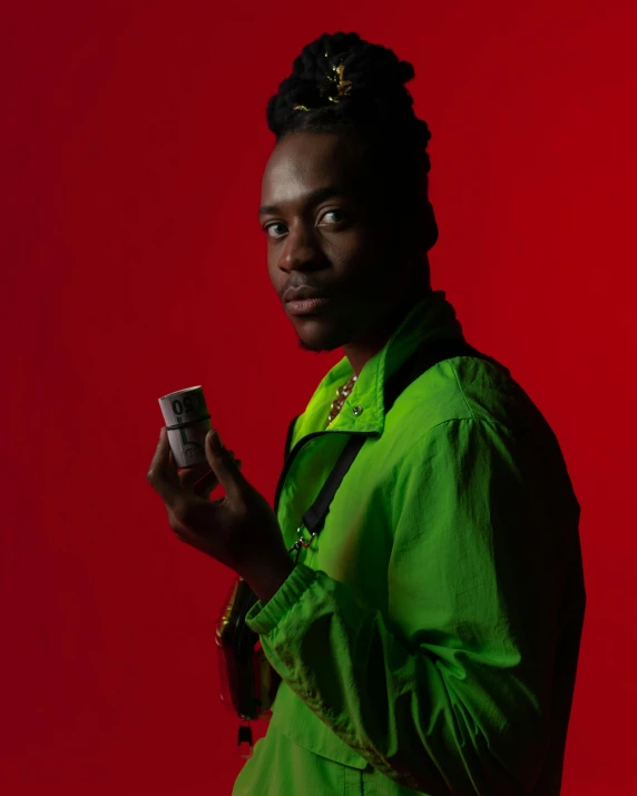 a man in a green jacket holding a cell phone, an album cover, pexels contest winner, afrofuturism, awkwardly holding red solo cup, an epic non - binary model, looking straight to the camera, roygbiv