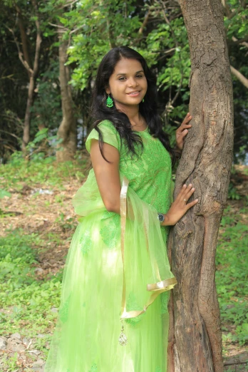 a woman in a green dress leaning against a tree, inspired by T. K. Padmini, happening, it\'s name is greeny, teenager, at college, in lake