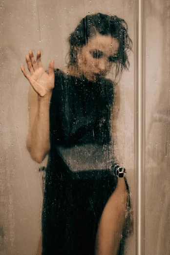 a woman in a black dress standing in a shower, a picture, inspired by Elsa Bleda, trending on pexels, wet t-shirt