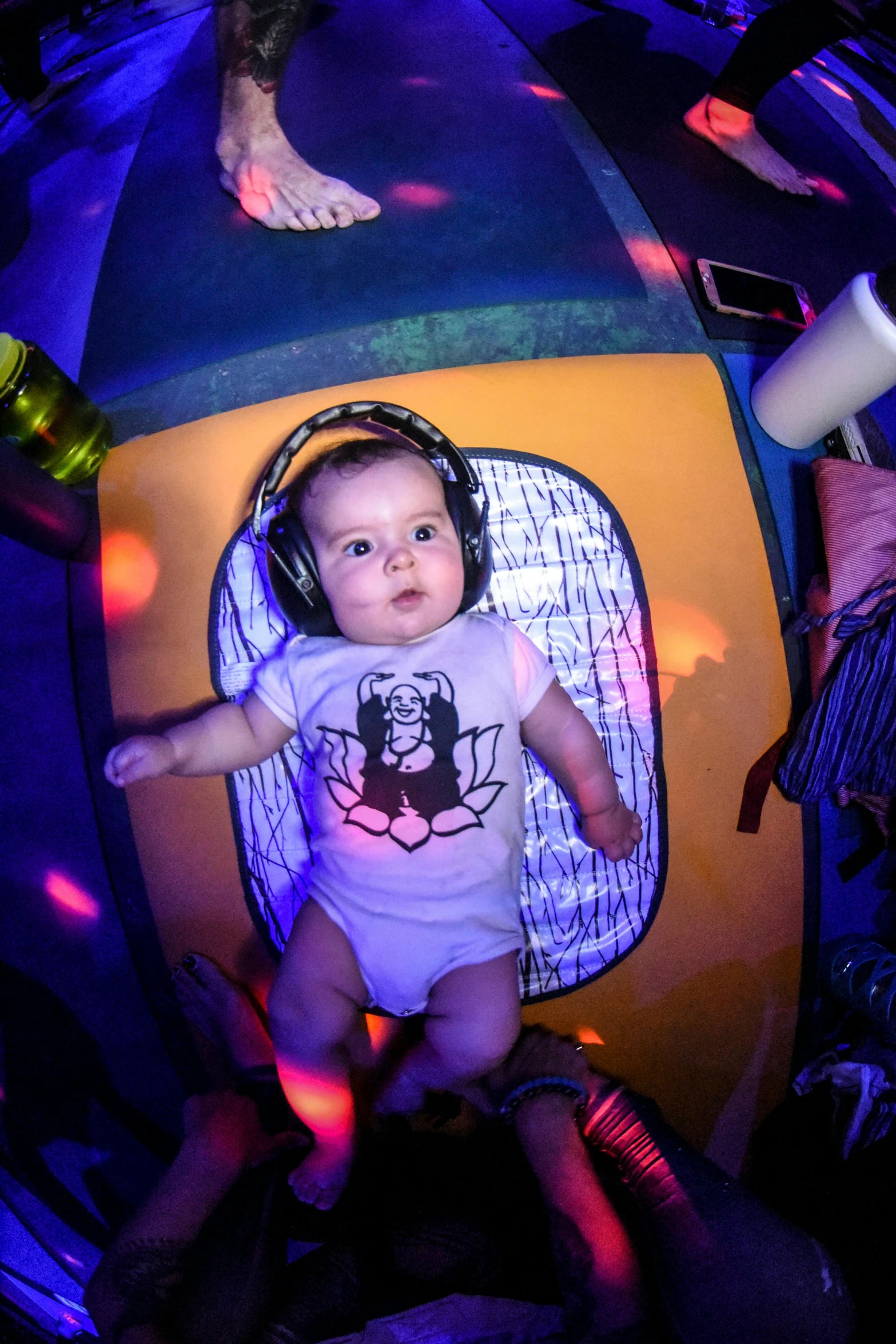 a baby sitting in a chair with headphones on, by Matt Cavotta, fun rave outfit, in intergalactic hq, lit from above, on a pirate ship