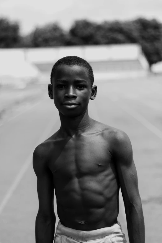 a black and white photo of a boy holding a skateboard, by Nadir Afonso, portrait of pele, shirtless, on a racetrack, nuri iyem