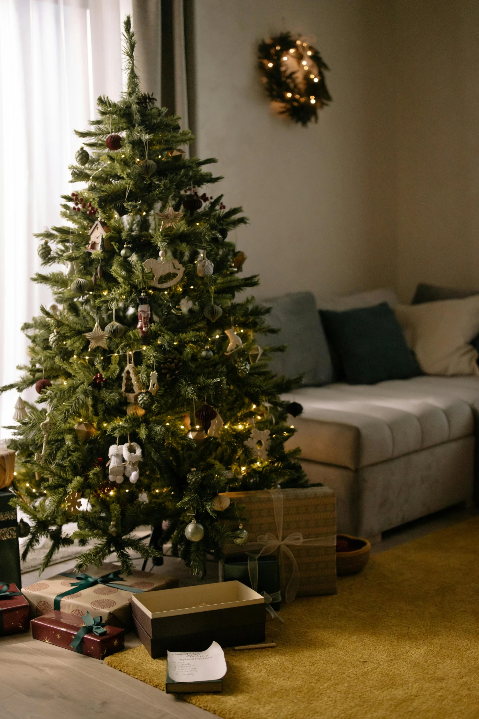 a living room filled with furniture and a christmas tree, a picture, pexels, delicate soft hazy lighting, big green tree, profile image, front facing