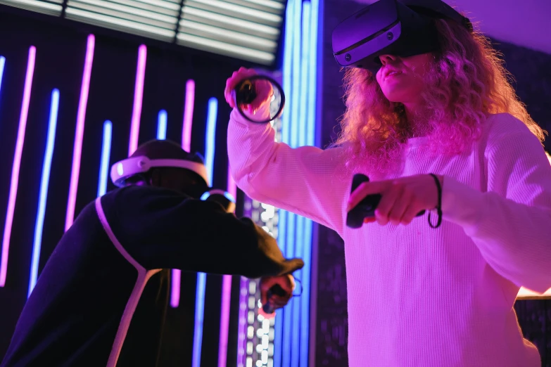 a man and a woman playing a video game, a hologram, pexels, interactive art, wearing black and purple robes, oculus quest 2, “house music rave with dancers, cardboard