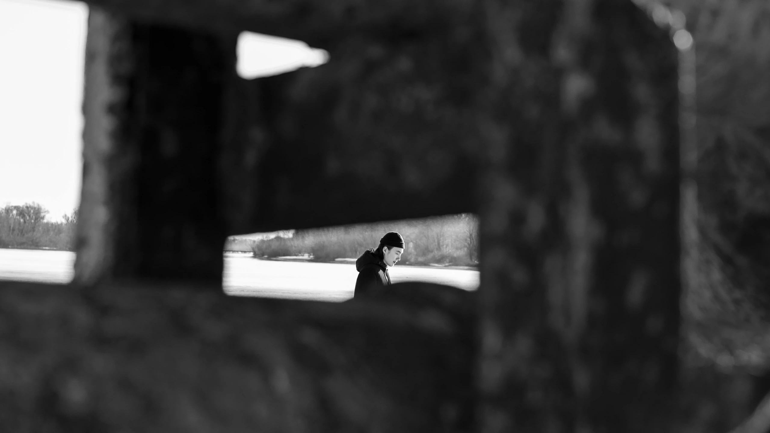 a black and white photo of a person holding an umbrella, a black and white photo, inspired by Sergio Larraín, unsplash, conceptual art, looking through a portal, winter photograph, exposed inner structure, 8k 50mm iso 10