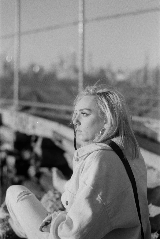 a black and white photo of a woman sitting on a bench, inspired by Louisa Matthíasdóttir, billie eilish, on a bridge, petra collins, gif