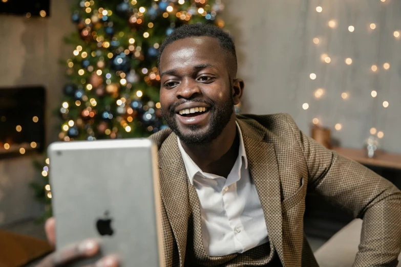 a man taking a selfie in front of a christmas tree, happening, emmanuel shiru, using a magical tablet, with apple, profile image