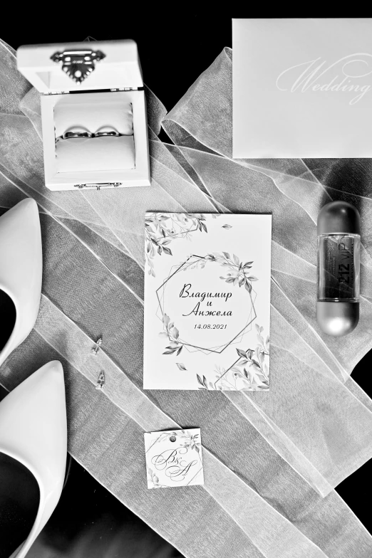 a couple of shoes sitting on top of a table, a black and white photo, invitation card, rings, -4