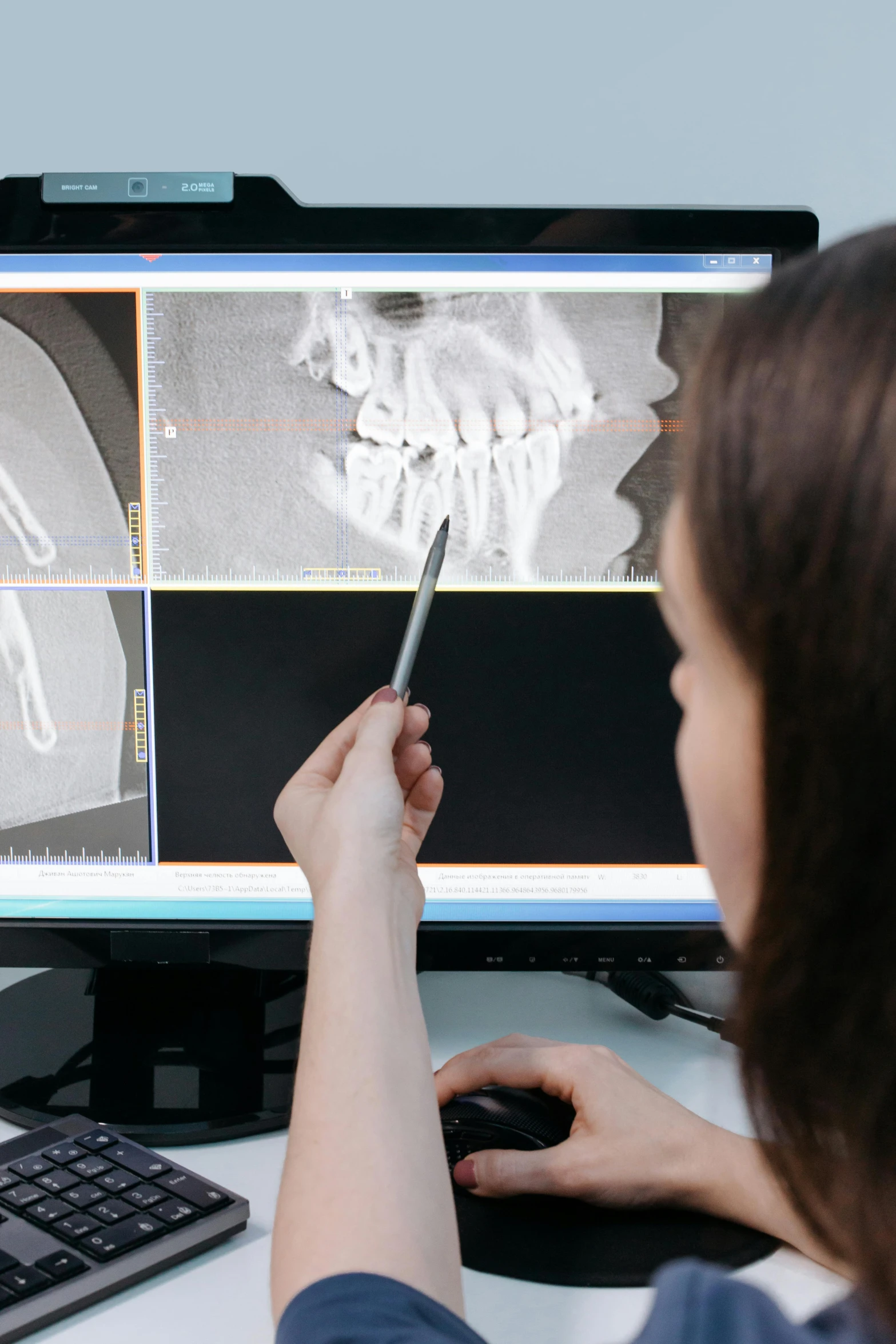 a woman sitting at a desk in front of a computer, by Adam Marczyński, trending on reddit, holography, the jaw showing the teeth, medical photography, medium closeup, surgical equipment