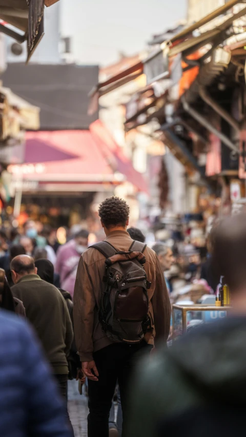 a group of people walking down a crowded street, trending on unsplash, renaissance, a man wearing a backpack, inside an arabian market bazaar, person in foreground, australian