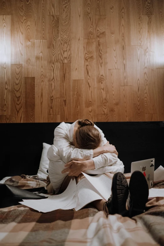 a woman sitting on top of a bed next to a laptop, by Jaakko Mattila, pexels contest winner, romanticism, two men hugging, in a hotel hallway, tears, bo burnham