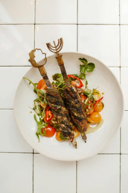 a white plate topped with meat and veggies, by Jessie Algie, dau-al-set, a pair of ribbed, skewer, rocket, south east asian with long