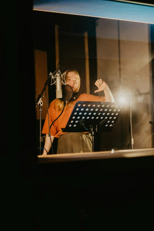 a man that is standing in front of a microphone, an album cover, by Else Alfelt, pexels, studio room, singing, kirsi salonen, in a studio